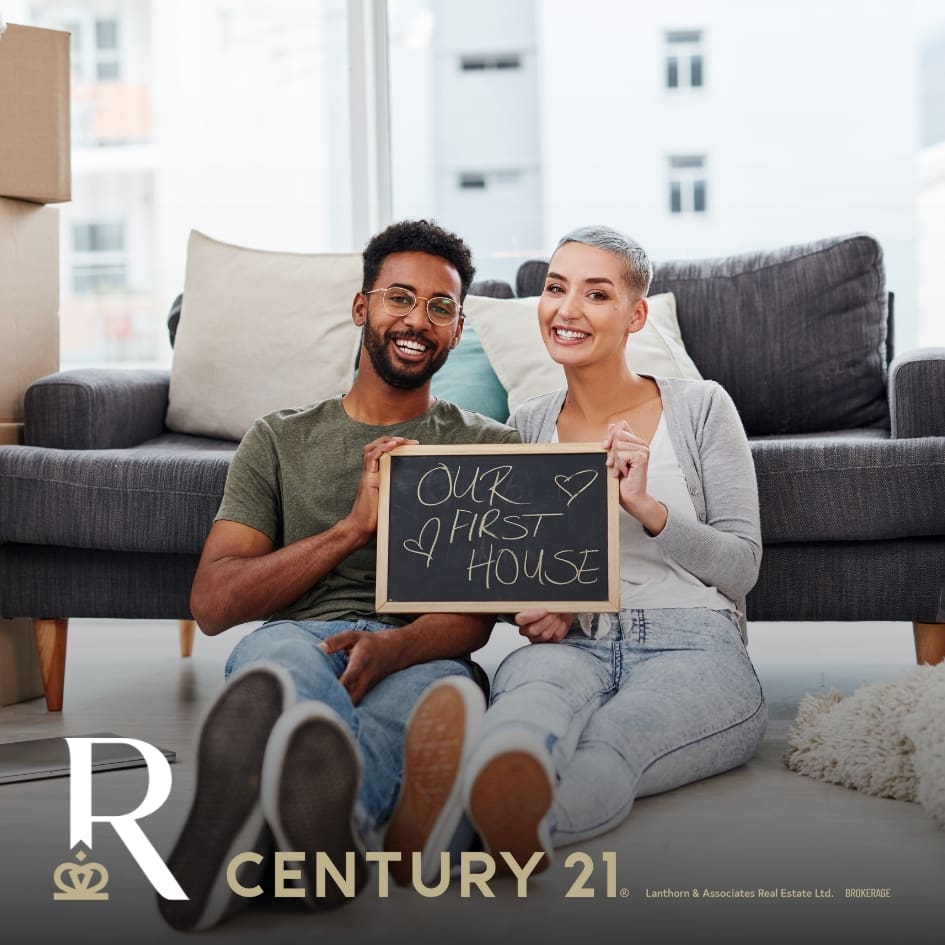 First Time Home Buyers holding a "our first house" sign